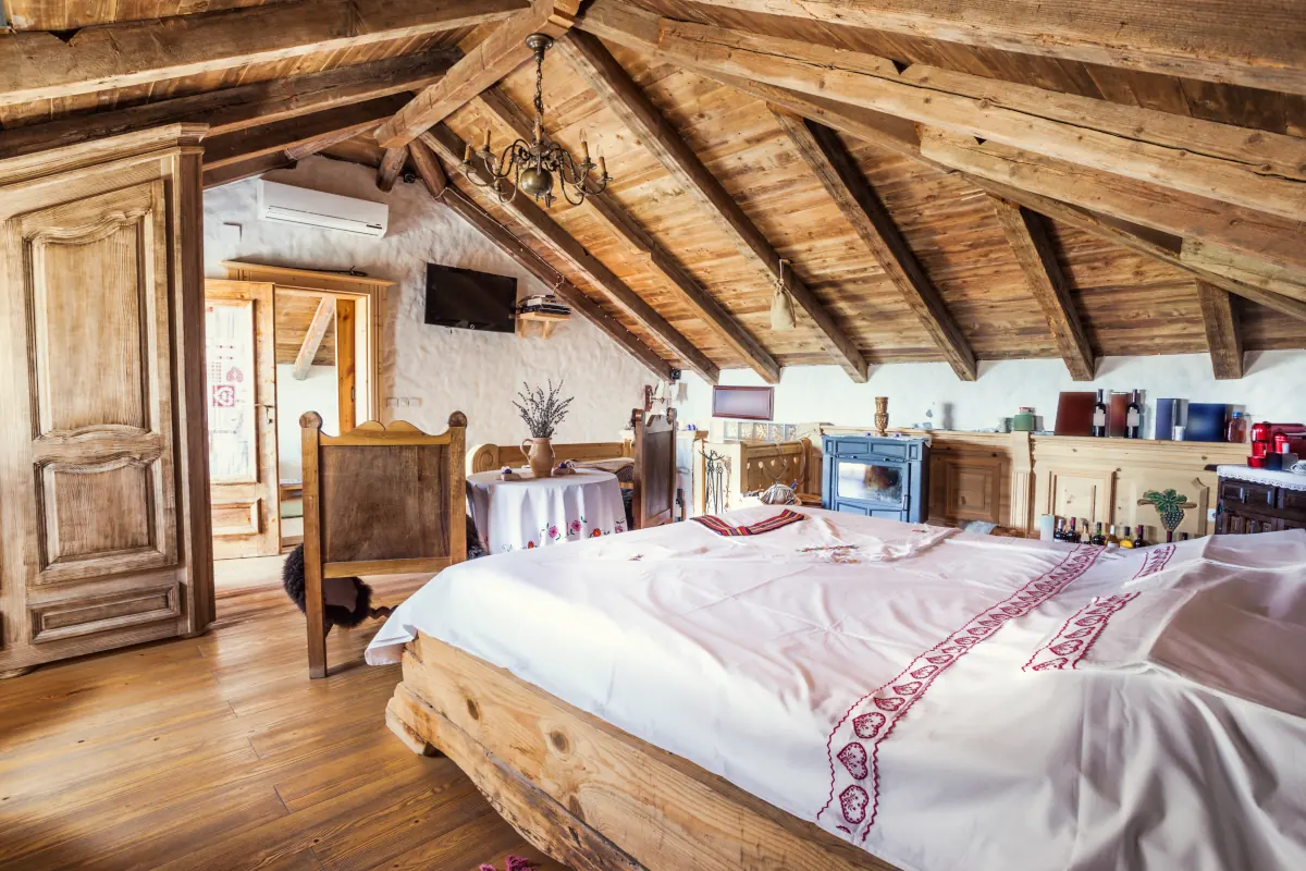 Sypialnia na poddaszu. Wszystkie meble wykonane z drewna.