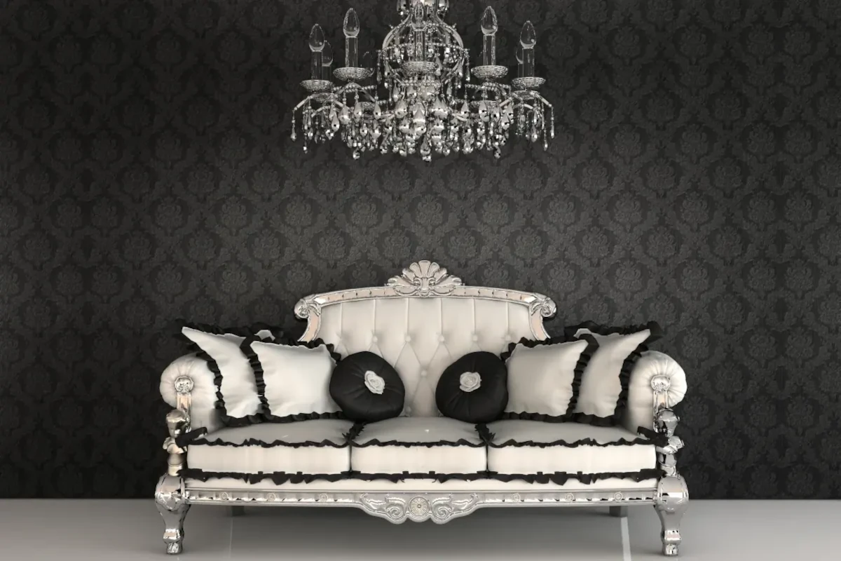 Sofa w stylu barokowym w jasnym barwach z czarnymi akcentami na tle czarnej ściany.