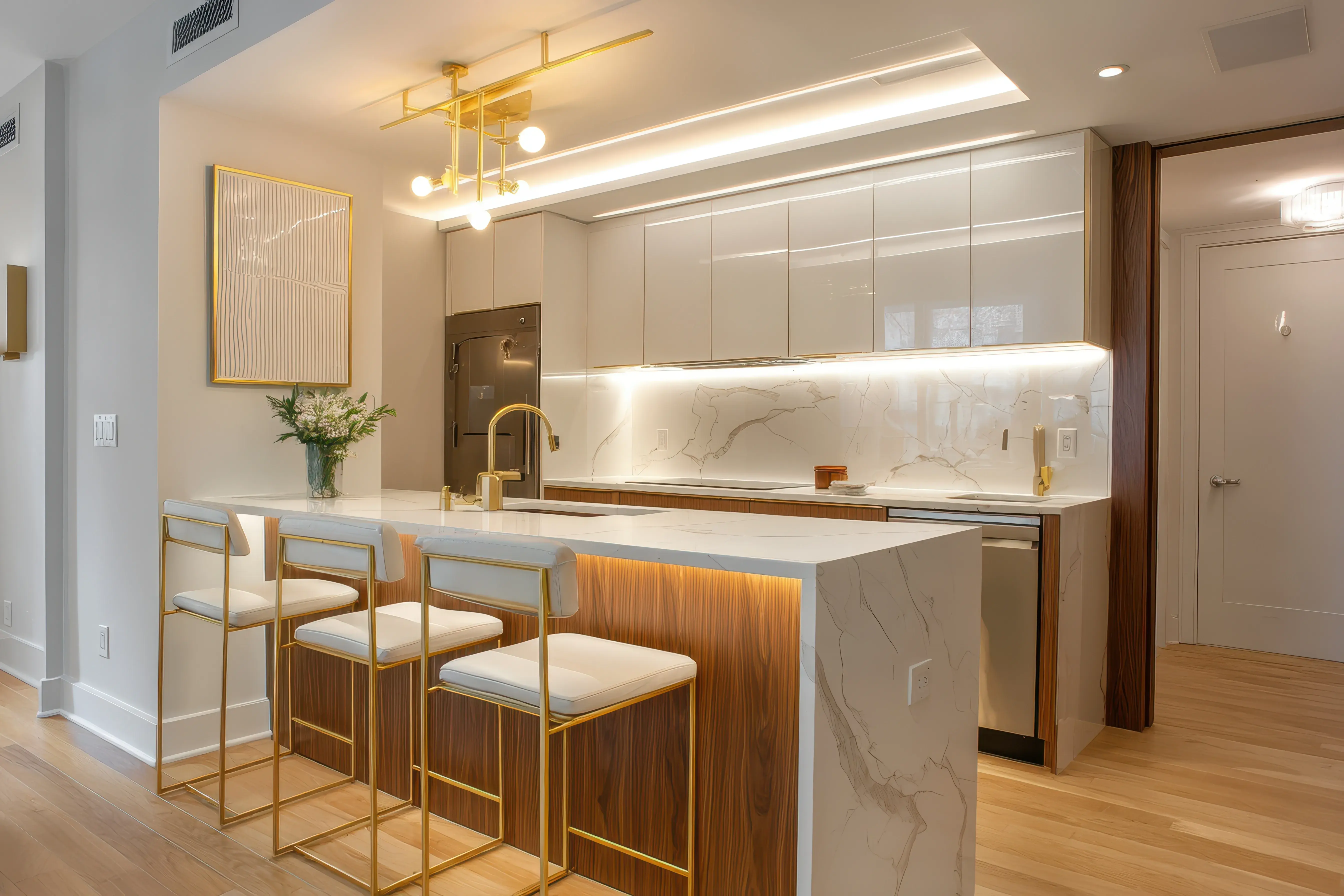 Kuchnia w stylu nowoczesnym z białą zabudową, półwyspem z marmurowym blatem i krzesłami.