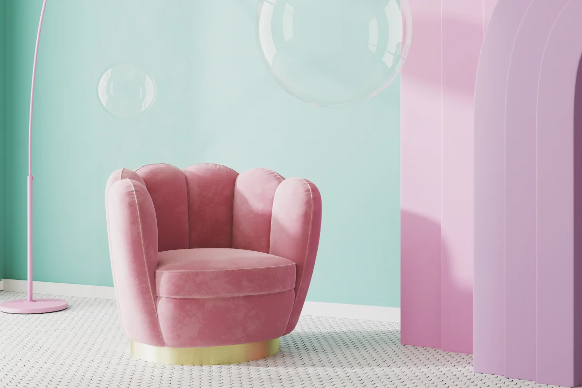 Różowy fotel stojący na środku pomieszczenia na tle zielonej ściany. Lampa oraz zasłony również w kolorze różowym.