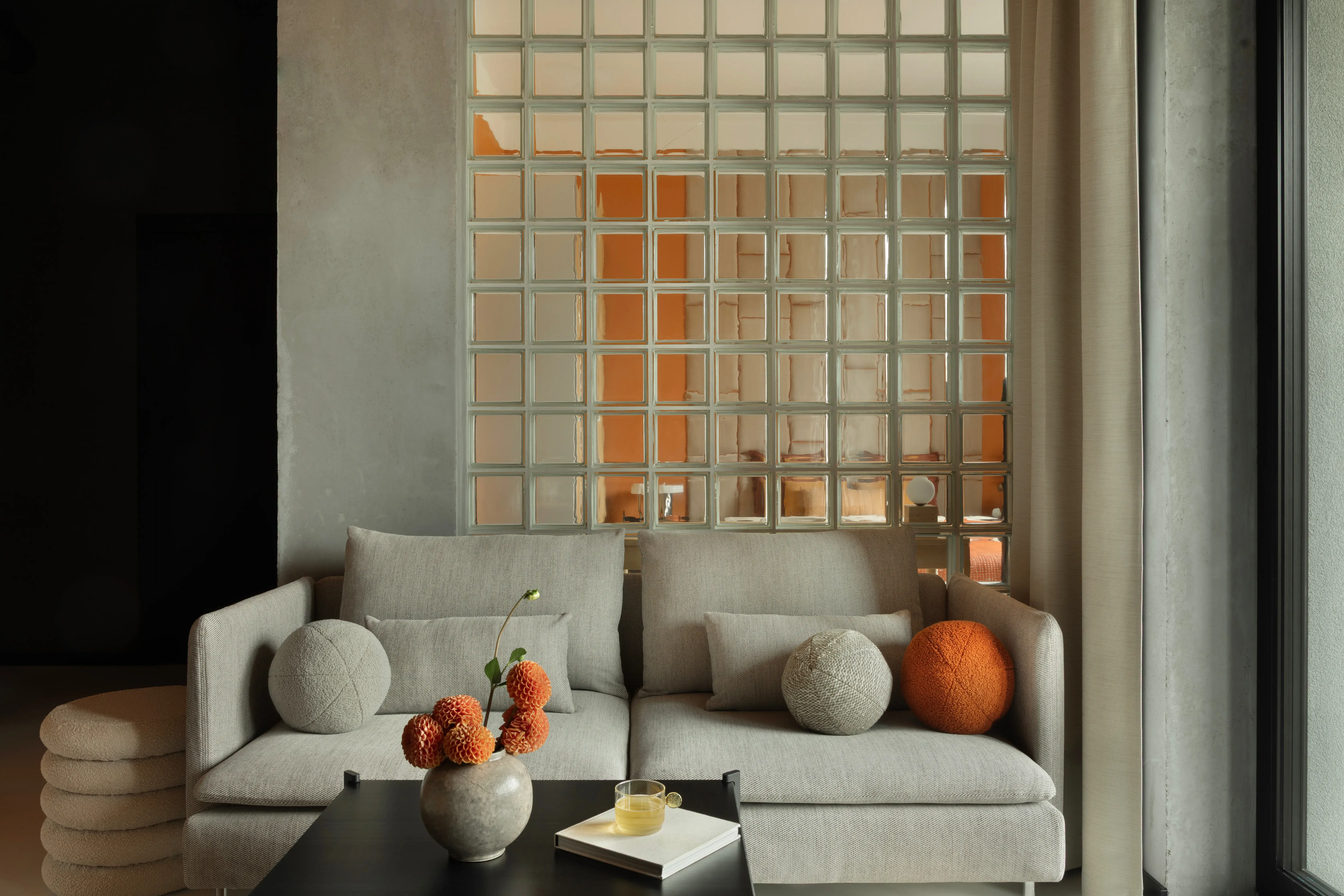 salon-bezowy-bialy-pomaranczowy-szklana-sciana-i-kanapa